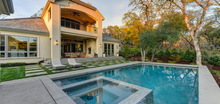 brown and white concrete house near green trees during daytime